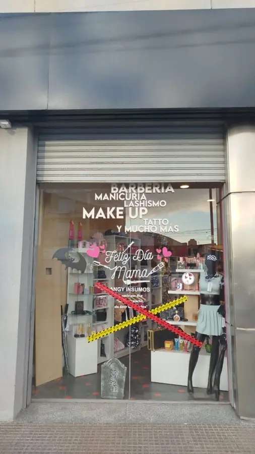 Cortina metálica de un local de maquillaje, subida